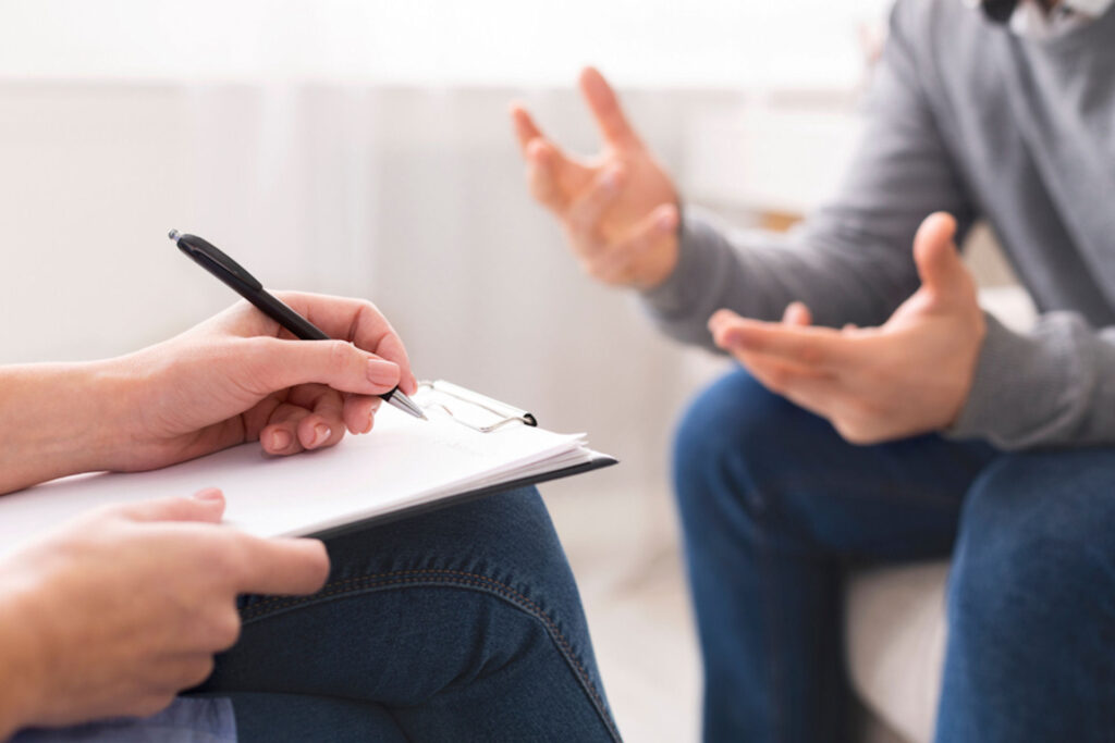 doctor taking notes on a client's symptoms