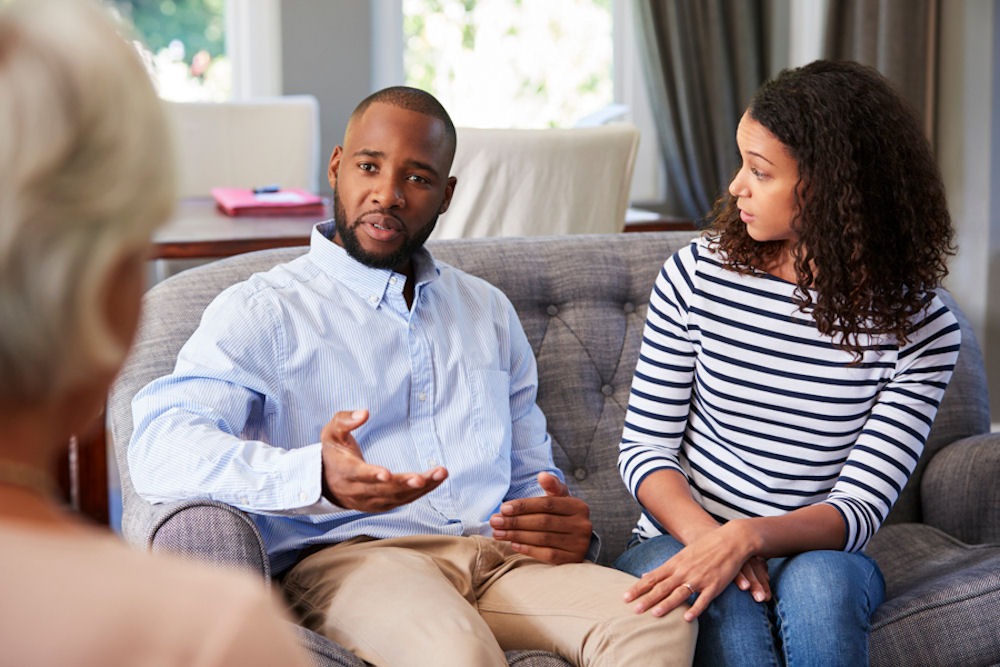 couple in therapy, sitting on couch discussing issues