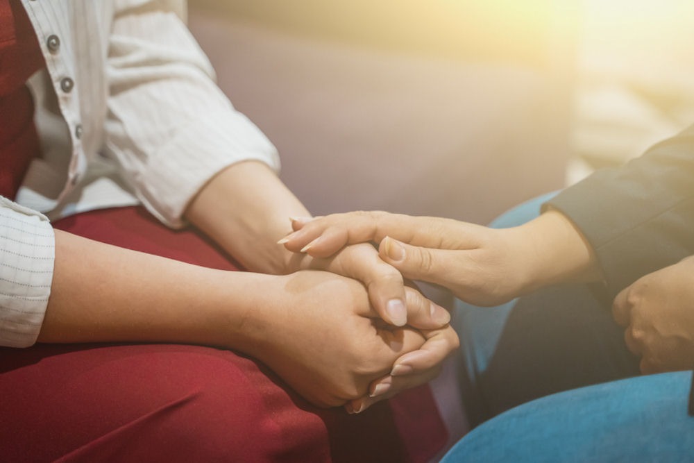 two people holding hands in support