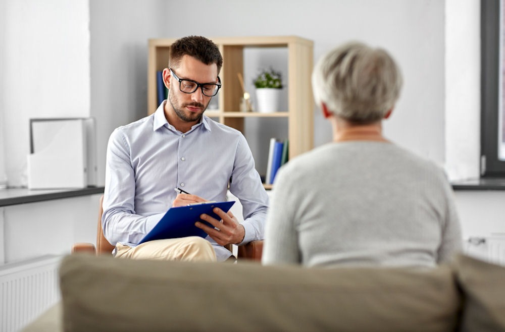 male therapist with senior woman in therapy