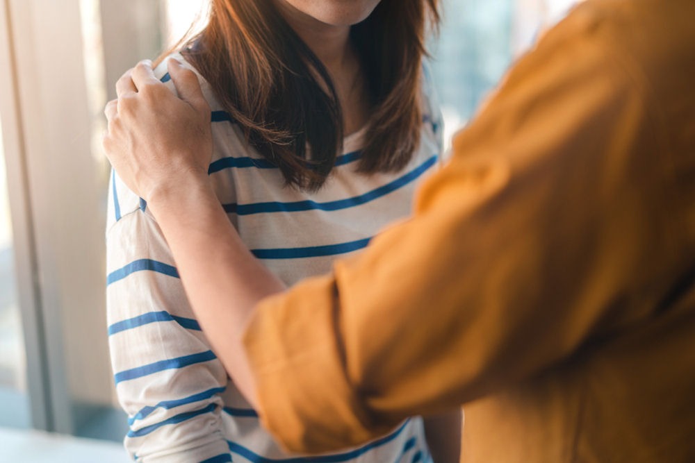 woman placing a supportive hand on her partner