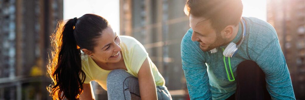 man and woman tying their shoes to prepare for a run