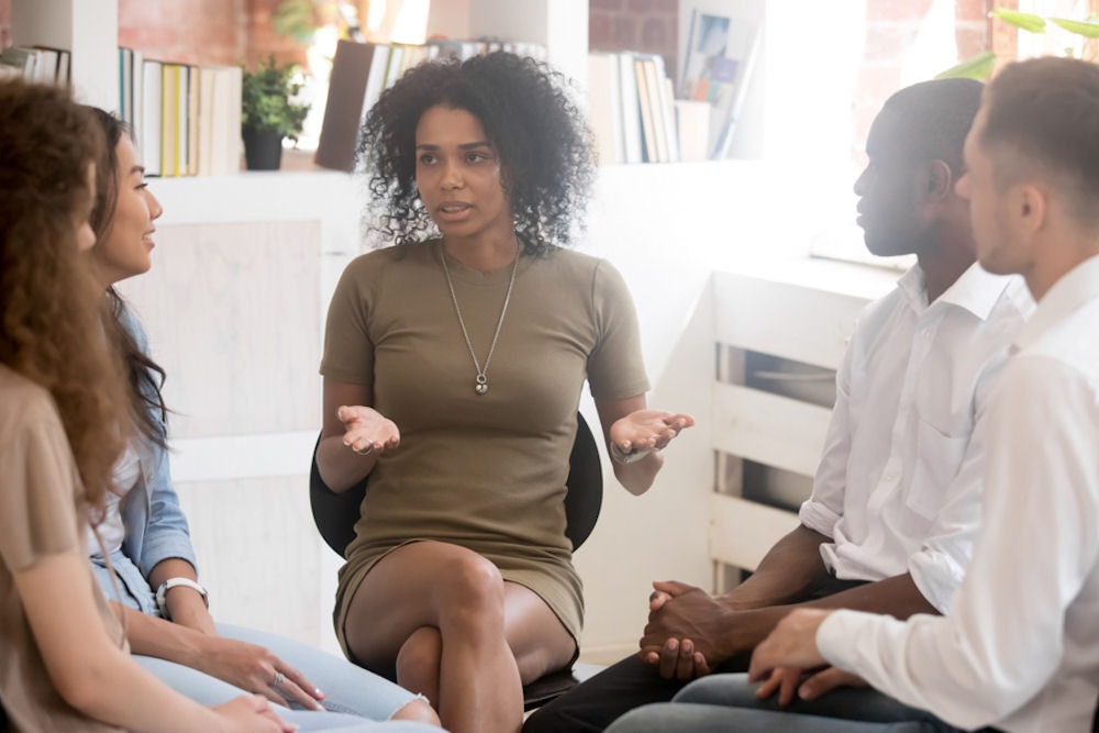 woman addressing small support group