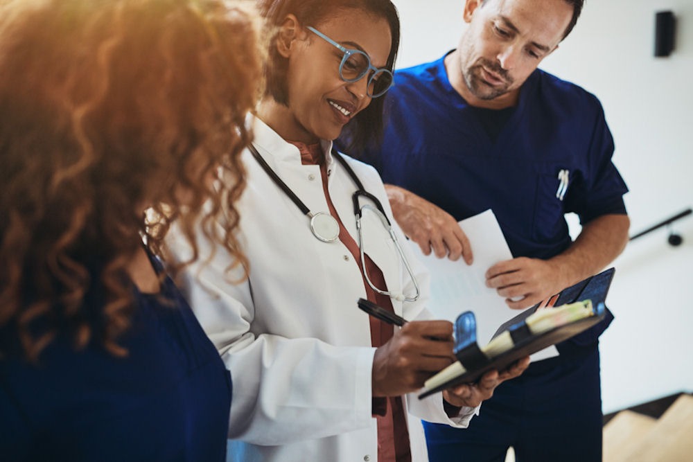 team of medical professionals reviewing a patient chart